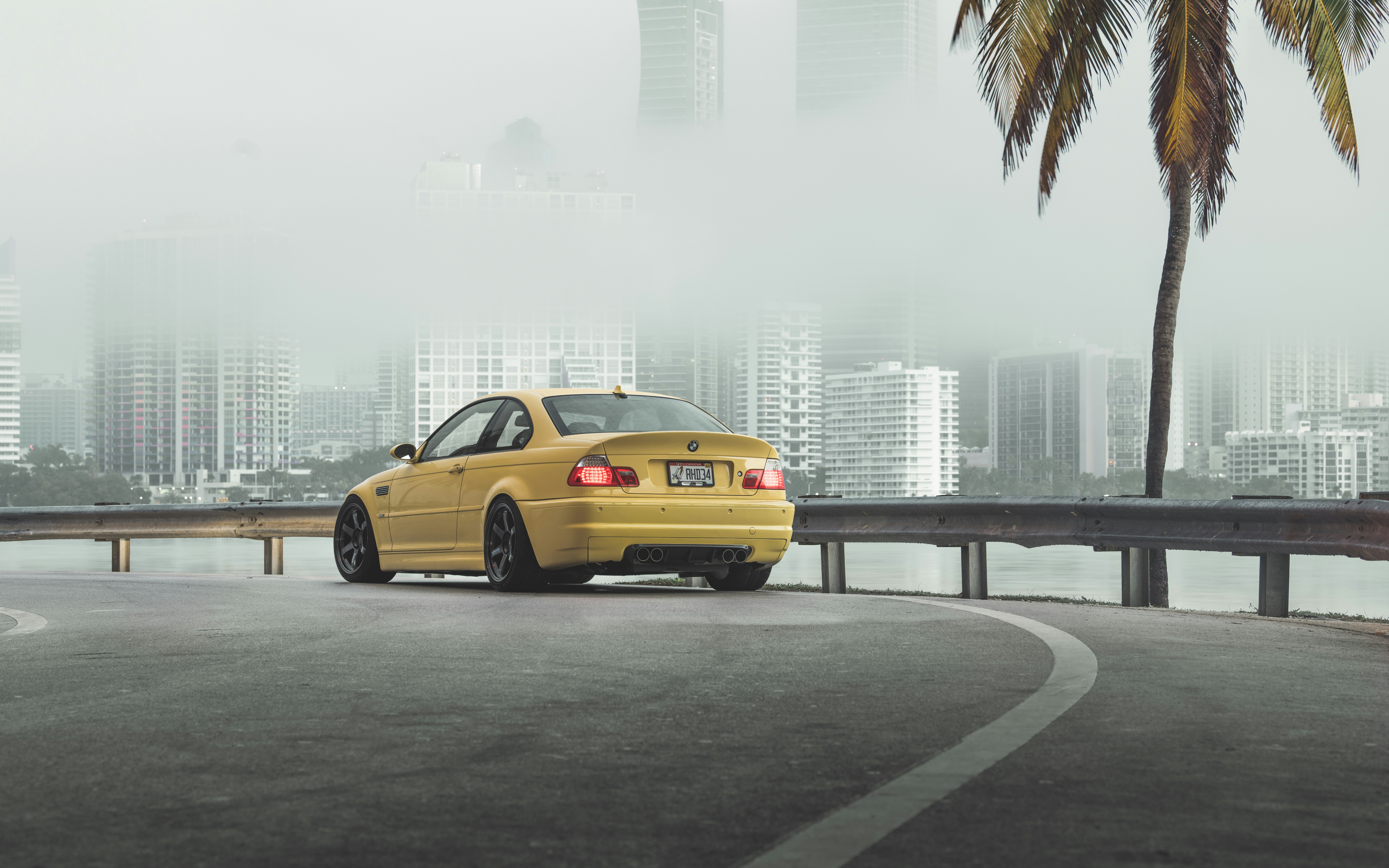 yellow sedan on road near city buildings during daytime